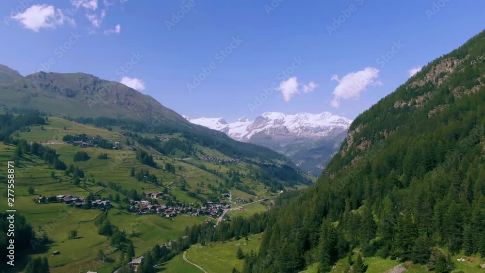 Aerial approaching view of Monte Rosa in the Italian Alps through pine trees Aerial approaching view of Monte Rosa in the Italian Alps through pine trees