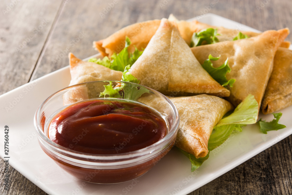 Samsa or samosas with meat and vegetables on wooden table . Traditional Indian food. Samsa or samosas with meat and vegetables on wooden table . Traditional Indian food.