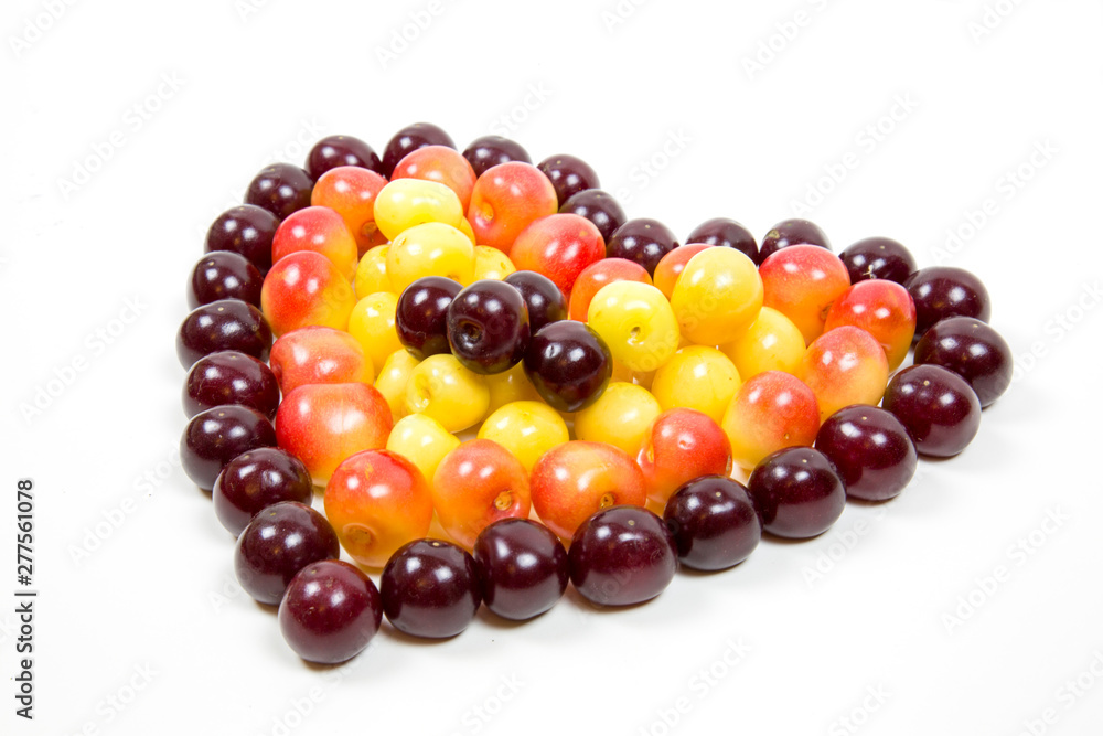 Cherry berries cherries in the form of a heart of red pink yellow isolated on a white background, a place for the text of the concept. Selective focus. Food ecology and agriculture. Background design. Cherry berries cherries in the form of a heart of red pink yellow isolated on a white background, a place for the text of the concept. Selective focus. Food ecology and agriculture. Background design.