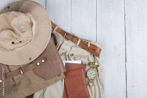 Prepare for journey in safari style, hiking and backpacker - accessories and travel items, packing clothes in backpack: backpack, passport, tickets, hat