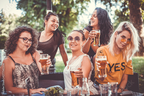 Happy group of female friends drinking beer - Friendship concept with young female friends enjoying time and having genuine fun at outdoor nature ambient