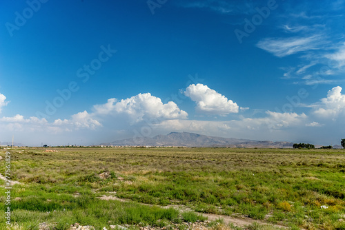 .incredibly beautiful landscape of sown field against the background of mountains and unsurpassed clouds in Shiraz,.Fars Province.Iran photo