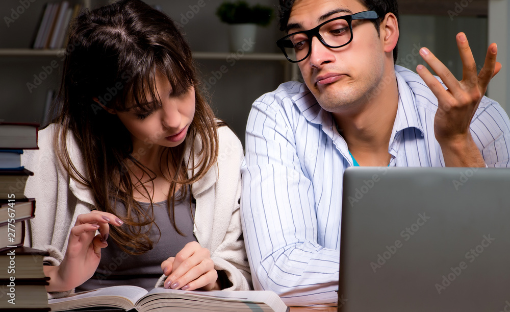 Two students studying late preparing for exams Two students studying late preparing for exams