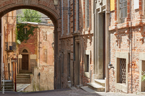 Street with red bricks buildings and ancient buildings in a sunny summer day in Mondovi  Italy
