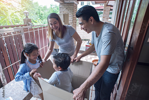 Happy family with cardboard boxes in new house at moving day.