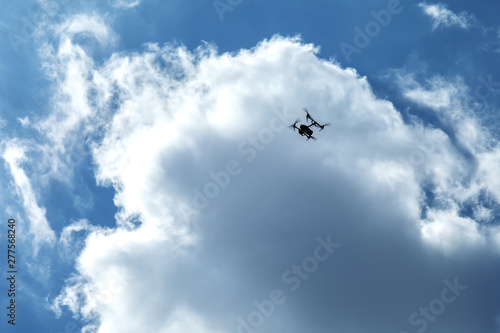 Flying quadrocopter on a background of clouds and blue sky