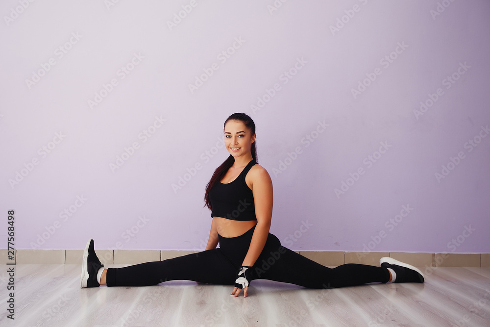 Fototapeta premium Stylish brunette in a black top. Woman spend time in a gym
