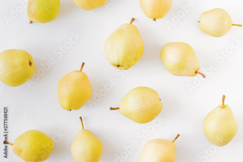 Flat lay pattern with yellow pears on a white background