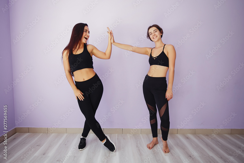 Stylish brunette in a black top. Women spend time in a gym Stylish brunette in a black top. Women spend time in a gym
