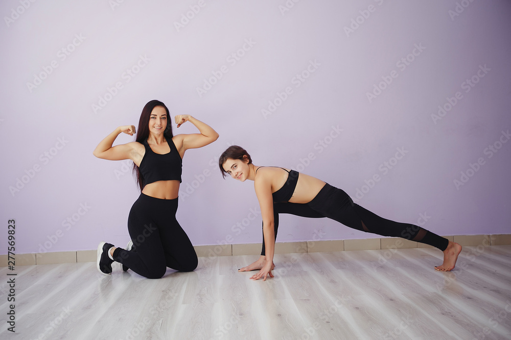 Obraz premium Stylish brunette in a black top. Women spend time in a gym