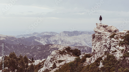 Man with hood looking at the horizon in a mountain landscape