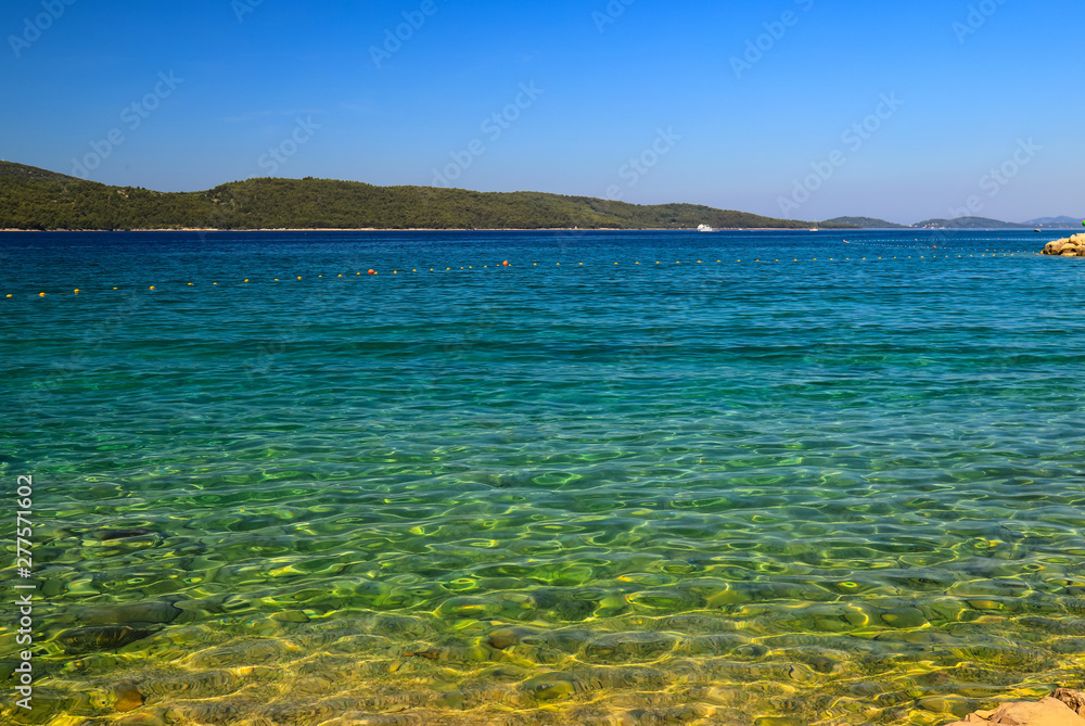 Sea background, Sibenik, Croatia. Transparent, clear water on an ecologically clean, picturesque summer beach. Beautiful sea. Croatian summer vacation, travel and tourism, text space