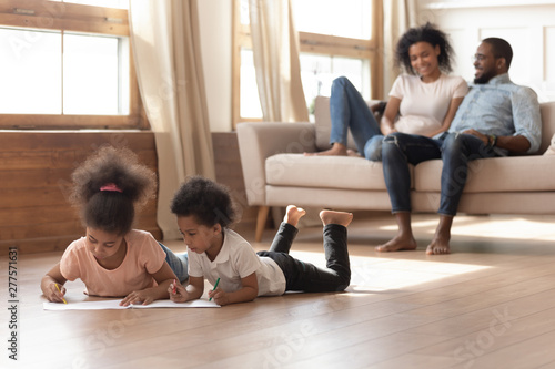 Happy african family with kids leisure activities in living room