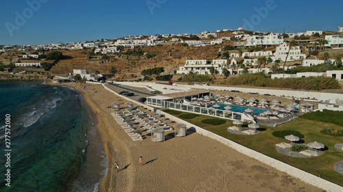 Aerial photo of famous sandy beach with turquoise clear sea of Megali Amos next to iconic and picturesque main town of Mykonos island  Cyclades  Greece