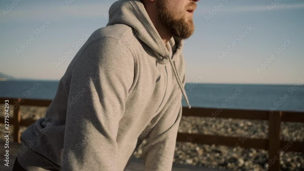 Bearded man is practicing sports on open air in summer morning