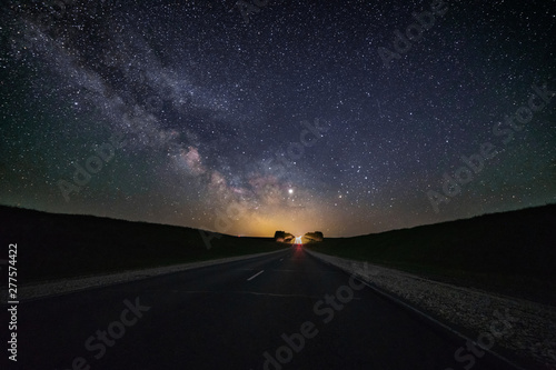 Fototapeta Naklejka Na Ścianę i Meble -  Night trip on the road, under a starry sky and the Milky Way.