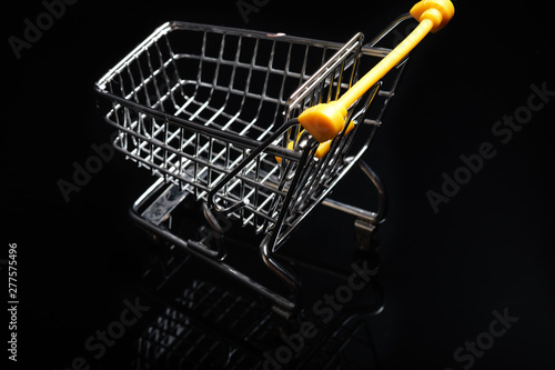 Close-up of shopping carts on black background.Trolley, Sale concept.Empty grocery shopping cart. Isolated over black background.