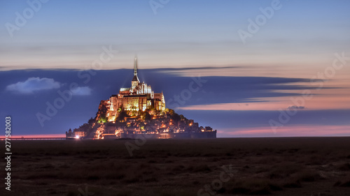 Illuminated Mont Saint Michel at dusk in a colourful sky with clouds on summertime, France
