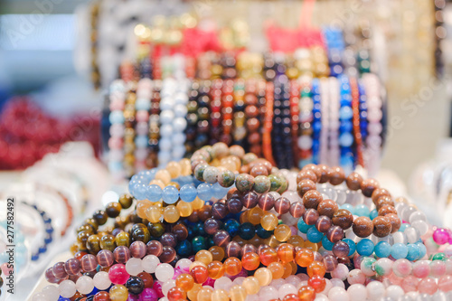 Various beautiful gem bracelets stacked together for sale in the market. photo