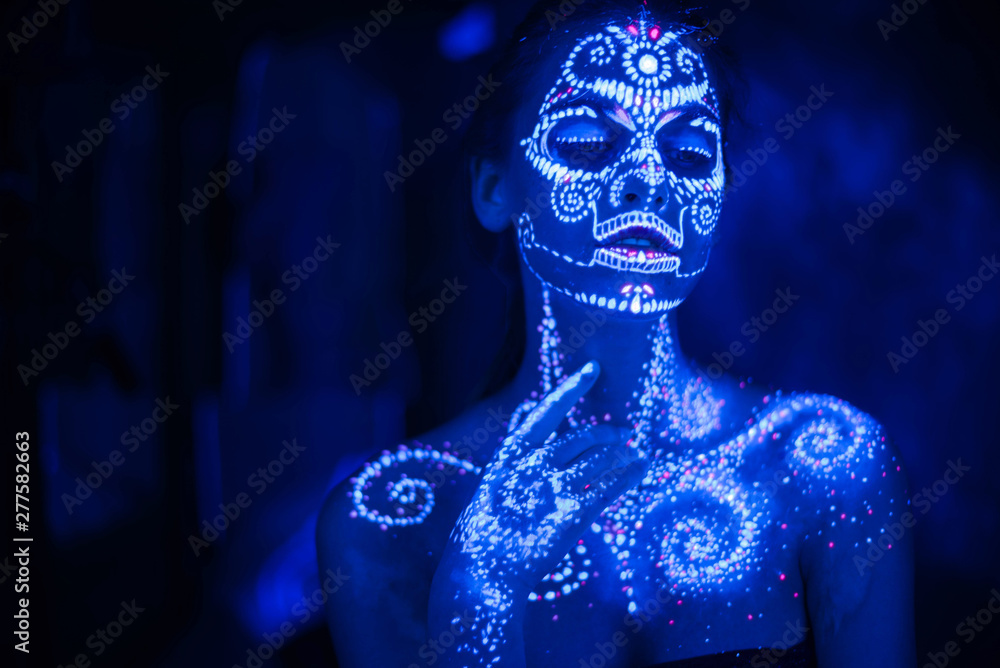 Body art on the body and hand of a girl glowing in the ultraviolet light. Body art on the body and hand of a girl glowing in the ultraviolet light.