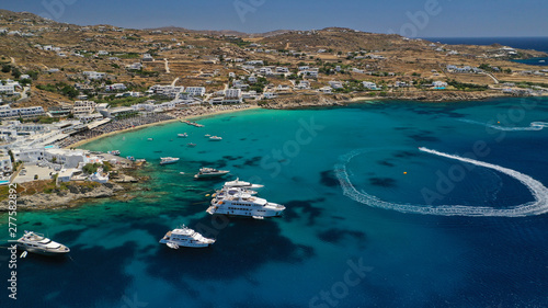 Aerial panoramic photo of famous turquoise clear sea celebrity sandy beach and bay of Psarou with yachts and sail boats in iconic island of Mykonos, Cyclades, Greece © aerial-drone