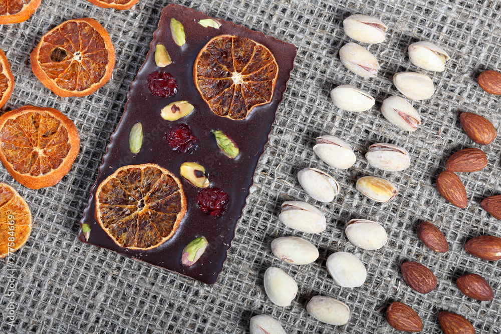 Dried orange slices, pistachios and almonds are laid out in rows on coarse linen fabric. Dried orange slices, pistachios and almonds are laid out in rows on coarse linen fabric.