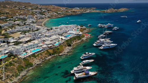 Aerial panoramic photo of famous turquoise clear sea celebrity sandy beach and bay of Psarou with yachts and sail boats in iconic island of Mykonos, Cyclades, Greece © aerial-drone