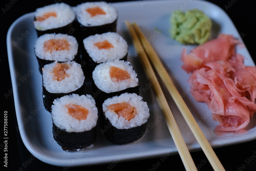 Sushi roll with seafood and soy sauce, wasabi and ginger. Sushi roll on a black background Sushi roll with seafood and soy sauce, wasabi and ginger. Sushi roll on a black background