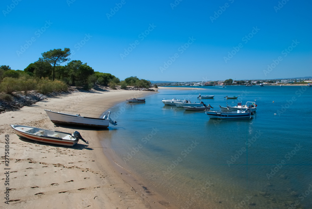 Beach and boats in the water at Tavira Island known as Ilha de Tavira in the Algarve in Portugal
