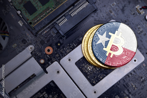 golden bitcoins with flag of texas state on a computer electronic circuit board. bitcoin mining concept. photo