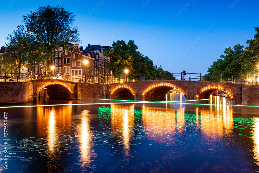 Illuminated Bridge in Amsterdam Canal at night