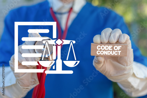 Quadro su tela Medical worker holding wooden block with code of conduct collocation and touching document sheet with scales icon