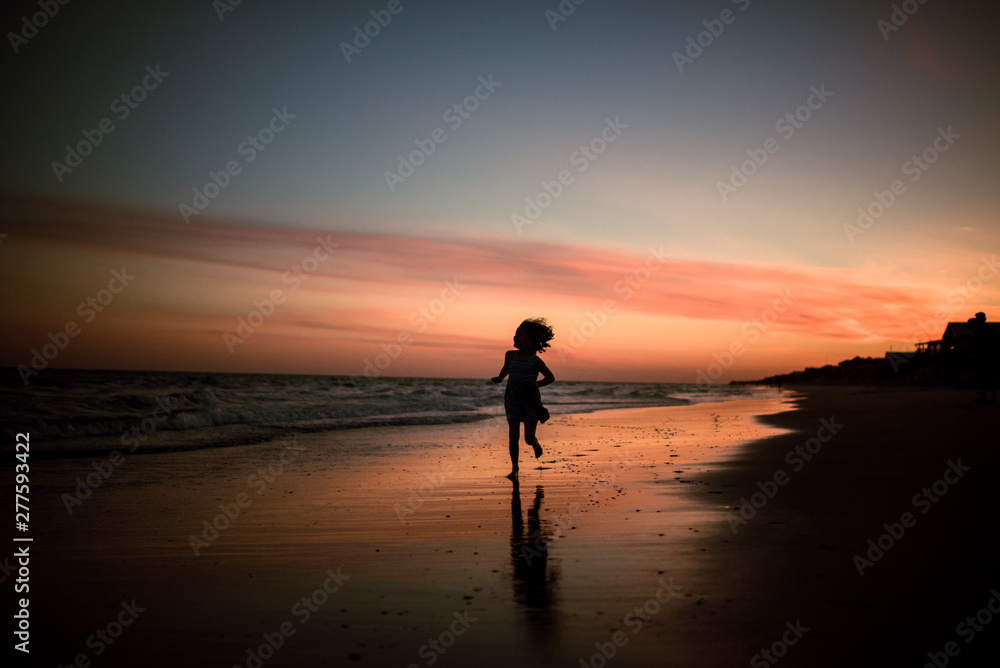 child running on beach at sunset child running on beach at sunset