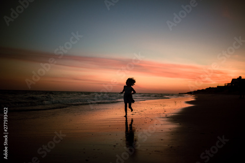 child running on beach at sunset 