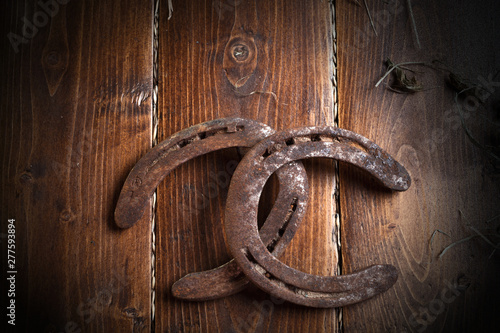 Equesrtian background. Lucky old  horseshoes laying at wooden background. photo