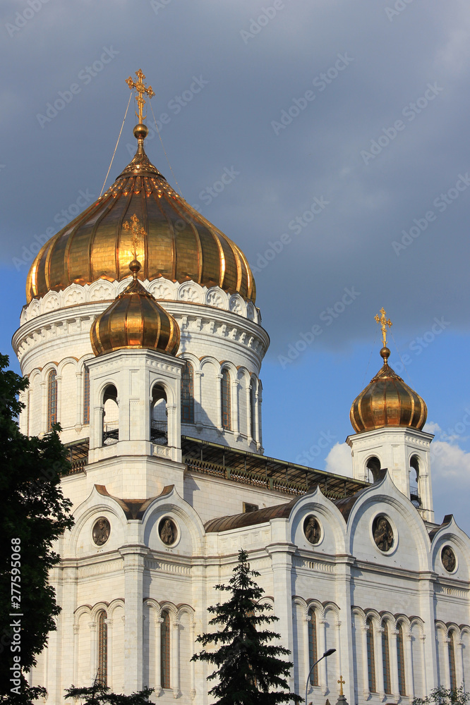 Cathedral of Christ the Saviour close up view in Moscow, Russia. Religious city landmark with golden domes and white facade walls on cloudy summer day 