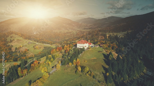 Colorful Sunset Mountain Peak Aerial View. Majestic Highland Landscape, Wild Forest Scenery, Natural Environment. Hill Countryside Village Hotel. Tourism Travel Concept. Drone Flight