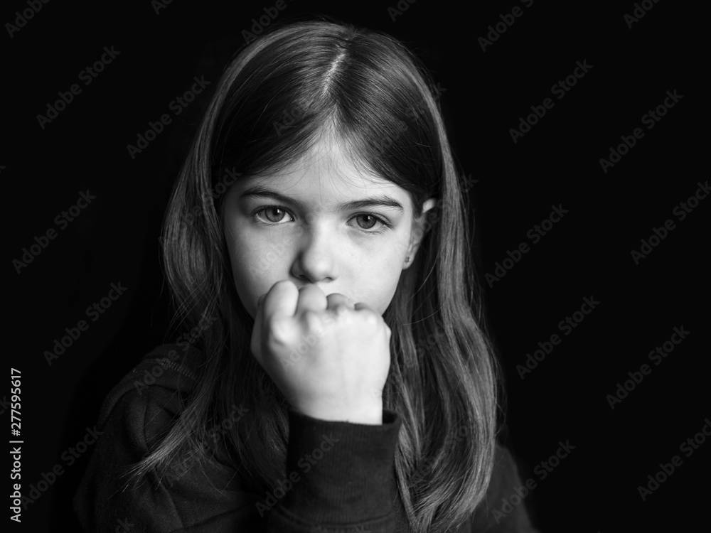 portrait of a little angry girl showing fist and threatening portrait of a little angry girl showing fist and threatening