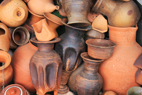 Pottery vessels and other objects made of clay and ceramic materials in a pile with broken earthenware, stoneware and porcelain