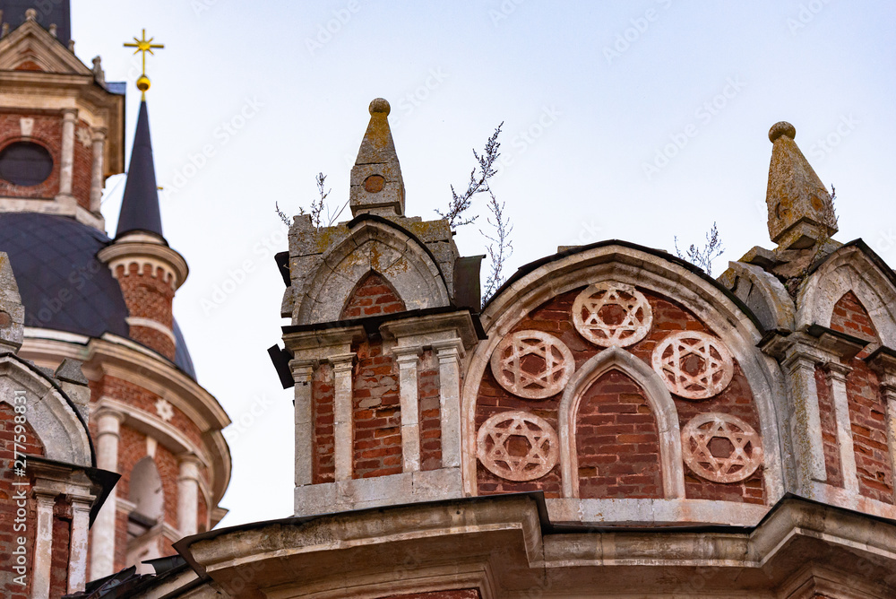 Fototapeta premium Gothic Orthodox Cathedral. Neo-Gothic Orthodox Church with Masonic symbols. Five-pointed star in a circle on the bas-relief of the temple.
