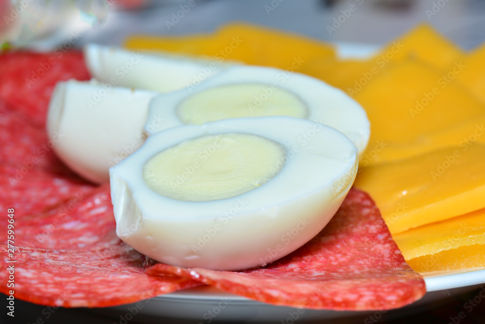 Cutting cheese and sausage, boiled eggs cut in half. Concept of gastronomic background, ingredients for a sandwich, background for the project and design. Cutting cheese and sausage, boiled eggs cut in half. Concept of gastronomic background, ingredients for a sandwich, background for the project and design.