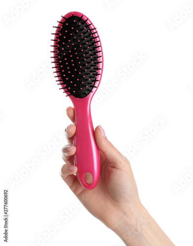 Woman holding hair brush against white background, closeup
