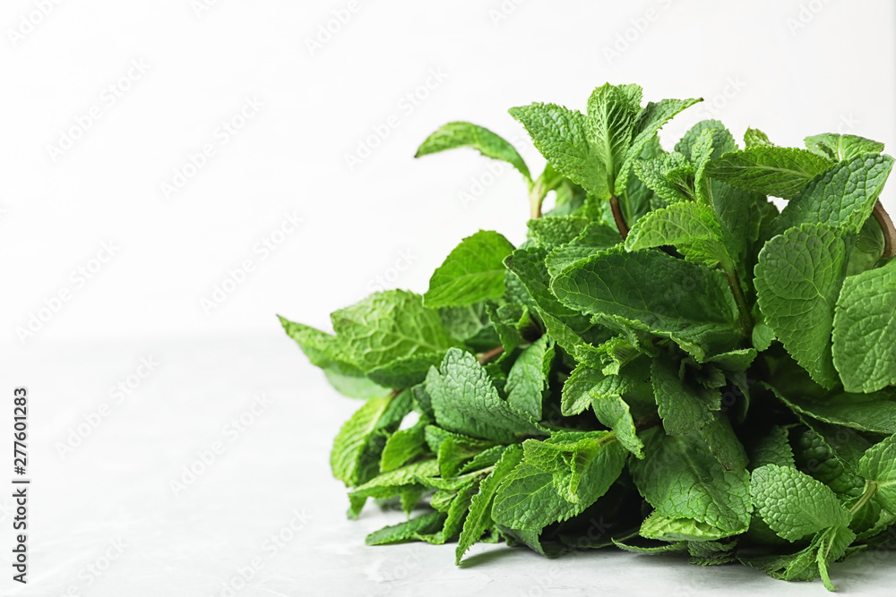 Bunch of fresh green mint on table, closeup. Space for text Bunch of fresh green mint on table, closeup. Space for text