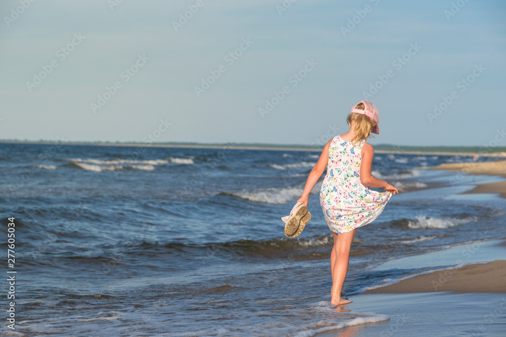 Obraz na płótnie dziewczynka w letniej sukience na morskiej plaży,  w salonie