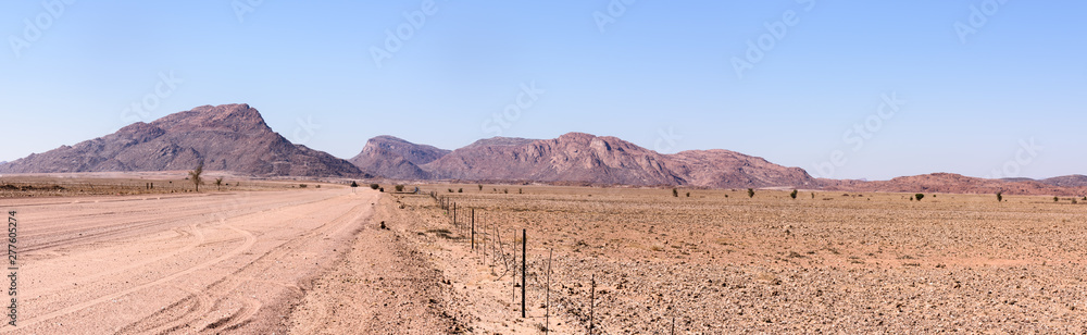 Gravel dirt road leading towards mountains in Central Namibia