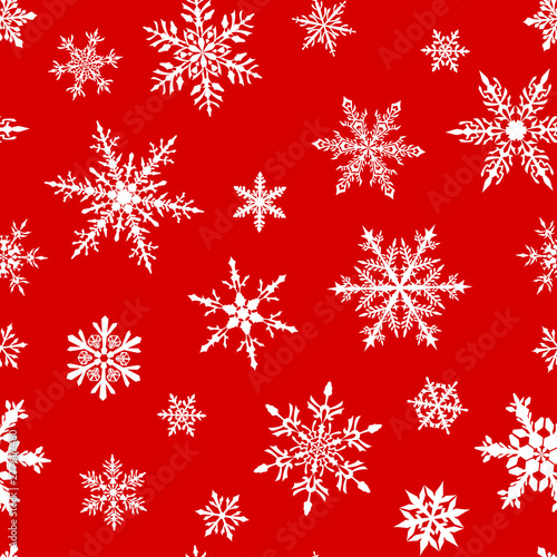 Christmas seamless pattern of complex big and small snowflakes in white colors on red background