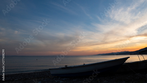 Sea ​​coast sunset and boat