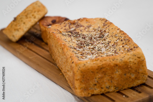 Homemade bread served on wooden table for breakfast. Healthy bakery concept. Bread with rye, sesame and wheat on top. Soft and spongy bread.