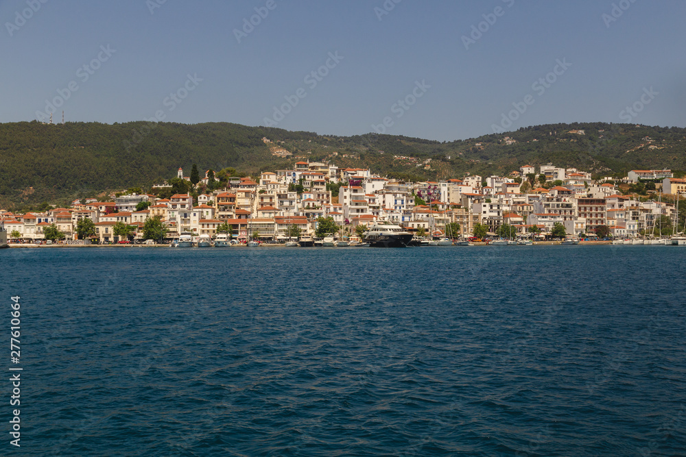 Landscape view to Skiathos island from the sea. Old bildings of town. Greece