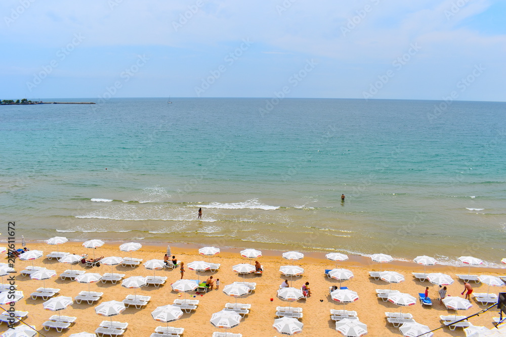 Sunbeds and parasols on a fine yellow sandy beach with crystal clear calm water behind The Bulgarian Black sea coast is great value for money destination popular amongst Brits for their summer getaway Sunbeds and parasols on a fine yellow sandy beach with crystal clear calm water behind The Bulgarian Black sea coast is great value for money destination popular amongst Brits for their summer getaway